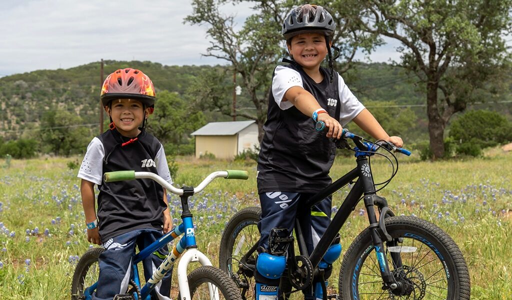 Two young brothers happy mountain biking