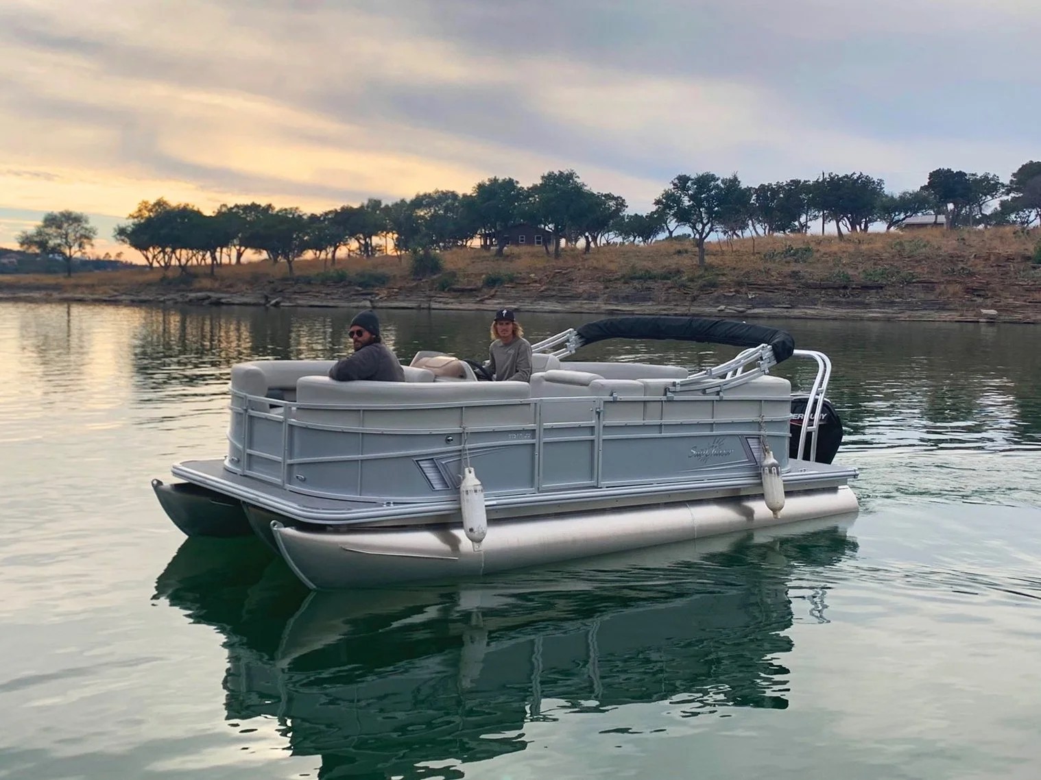 Pontoon boat cruising Lake Buchanan at sunset